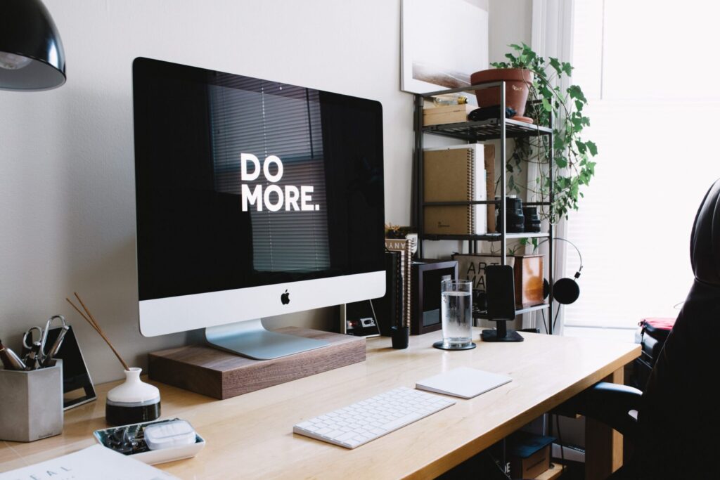 A desk set up and a monitor with the words "Do more." 