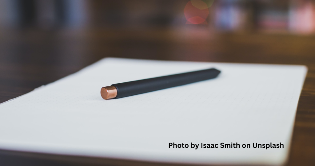 A pen and note pad sitting on a work desk