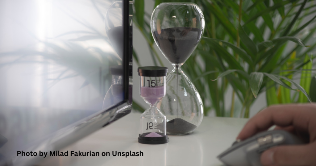 An hour glass, and a smaller 15 minute hour glass sitting on someone's work desk